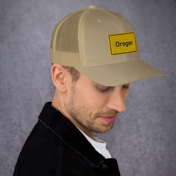 Ein Mann mit einer braunen Drogen-Trucker-Cap.