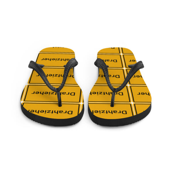 Ein Paar gelb-schwarze Drahtzieher-Flip-Flops mit einem „ekelhaften“ Motiv.