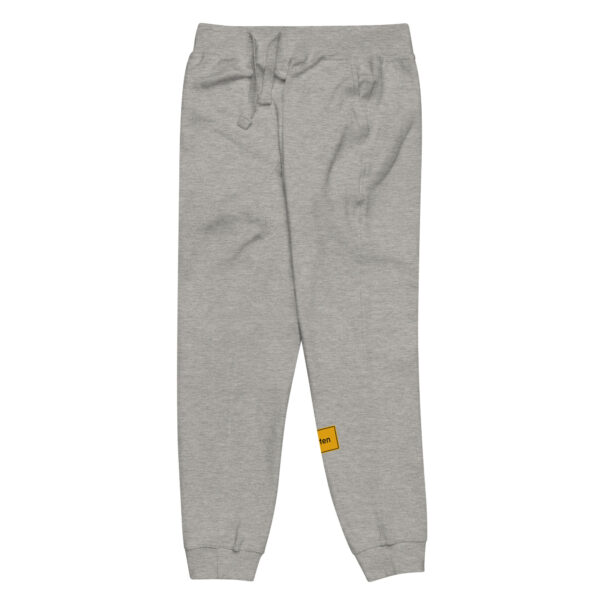 Eine Unisex-Fleece-Jogginghose, eine graue Jogginghose mit gelbem Etikett.