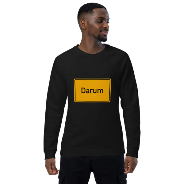 Ein Mann trägt ein schwarzes Sweatshirt mit der Aufschrift Unisex Bio-Raglan-Pullover darauf.