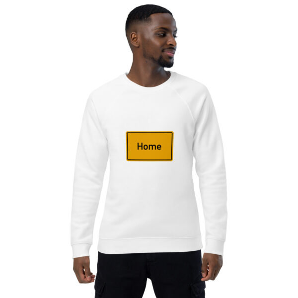 Ein Mann trägt ein weißes Unisex-Bio-Raglan-Pullover-Sweatshirt mit der Aufschrift „Home“ darauf.